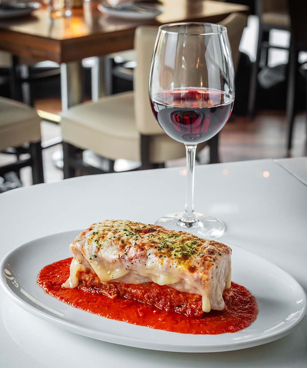 Close up of lasagna and a glass of red wine at Martini Modern Italian.