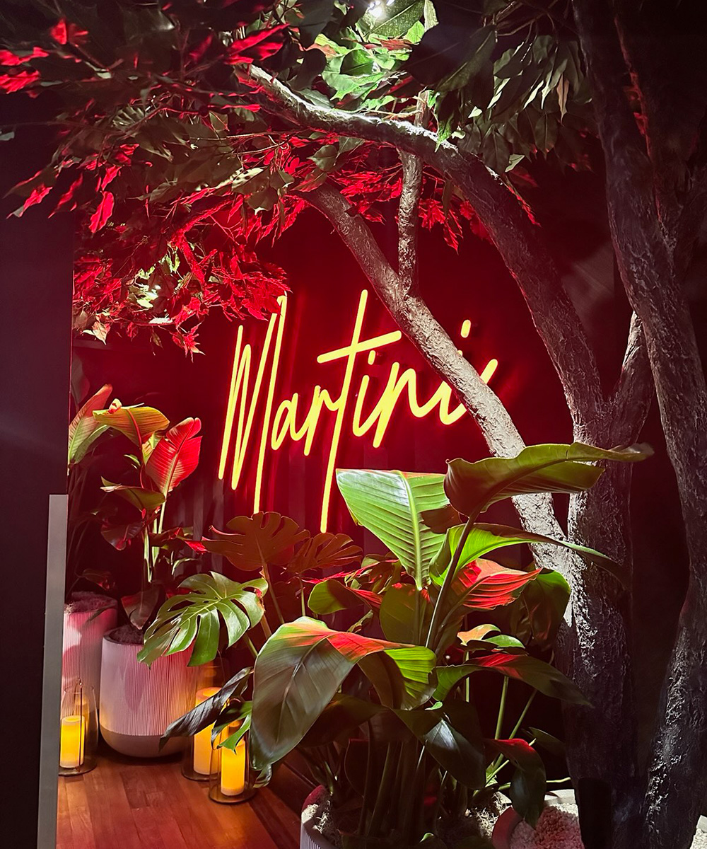 Neon sign reading 'Martini' hangs on a wall inside of Martini Modern Italian